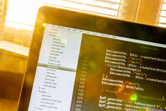 Modern software development background: nice looking laptop with programm on display.
