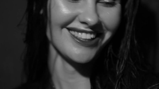 Fashionable girl posing in jeans in the studio. Black and white video.