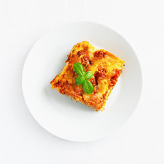 oven baked cannelloni covered with bechamell and tomato sauces sprinkled with mozzarella and parmesan cheese and decorated with basil 