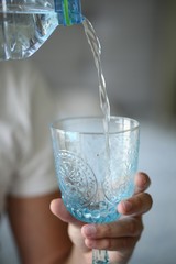 Man is poring the water into a glass