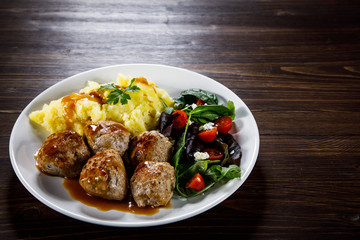 Roast meatballs with potatoes and vegetable salad