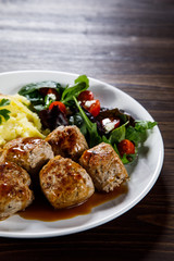 Roast meatballs with potatoes and vegetable salad