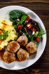 Roast meatballs with potatoes and vegetable salad