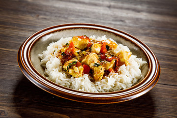 Grilled meat, white rice and vegetables on wooden table