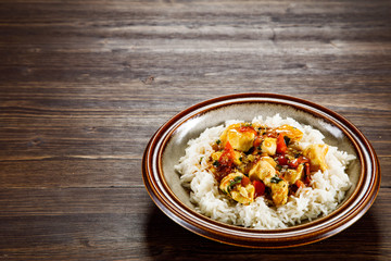 Grilled meat, white rice and vegetables on wooden table