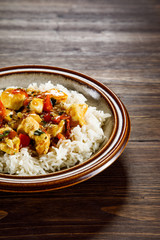 Grilled meat, white rice and vegetables on wooden table