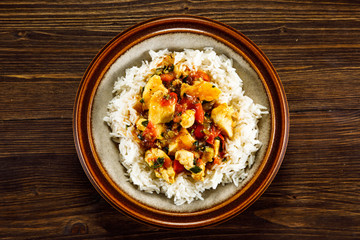 Grilled meat, white rice and vegetables on wooden table