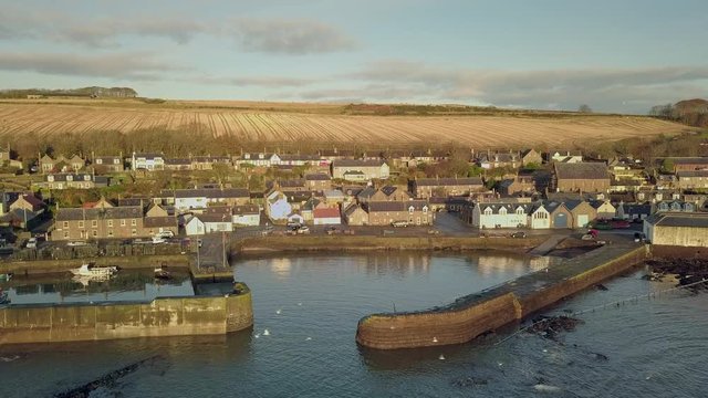 Aerial footage of Johnshaven harbour and town at sunrise, Aberdeenshire, Scotland