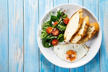 Breakfast - fried egg, toasts and vegetable salad