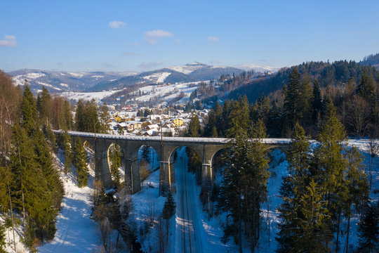 Winter scenery in Silesian Beskids mountains. Railwai viaduct in Wisla Glebce. Aerial view from above. Landscape photo captured with drone. Poland, Europe.