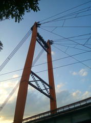 Orange cable-stayed bridge close-up against a blue clear sky