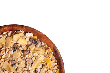 Breakfast oat flakes in wooden bowl with mix of dry fruits isolated on white.