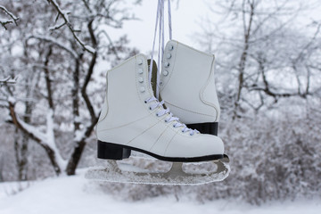 White women's ice skates on the background of the winter landscape
