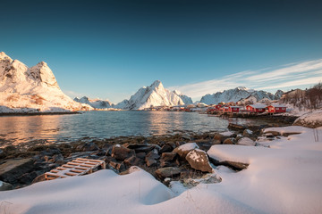 Scandinavian village in snowy mountain range on coastline