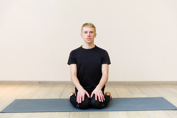 Sporty man practicing yoga on yoga class