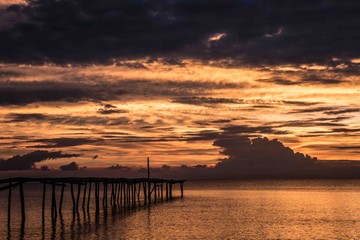 Naklejka na ściany i meble Dark sunset and clouds over Pier