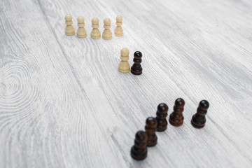 Black and white pawns on a wooden table