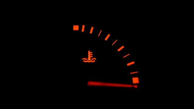 Color image of a car's oil icon lighting up on the dashboard. Arrow with reduction scale. 4k. Close-up footage.
