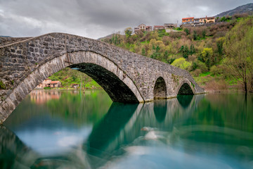 Fototapeta na wymiar Ancient stone arch bridge in Rijeka Crnojevica