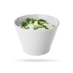 Ceramic bowl with delicious sour cream and herbs on white background