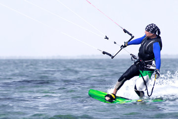 Naklejka na ściany i meble Kitesurfing. Man rides a kite in the sea