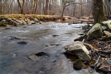 Water flowing around the rocks in a creek in the forest in winter, Potomac, Maryland, USA. Low...