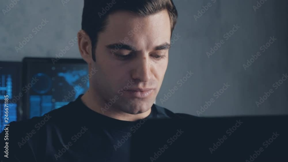 Wall mural developer programmer working on computer in a data center filled with monitor screens. steadicam sho