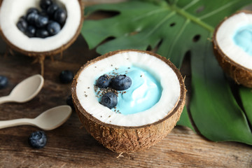 Fototapeta na wymiar Coconut with spirulina smoothie on wooden table