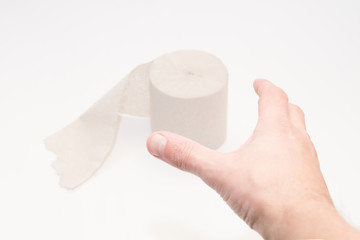 Toilet paper and hand on a white background. View from above