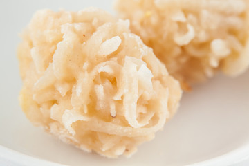Colombian traditional coconut sweet called cocada in a white ceramic dish
