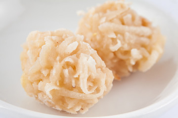 Colombian traditional coconut sweet called cocada in a white ceramic dish