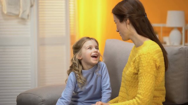 Happy laughing girl telling smiling mommy funny stories, trustful relations