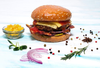 Juicy beef burger with onion, bacon, cucumber on a white background. Side view