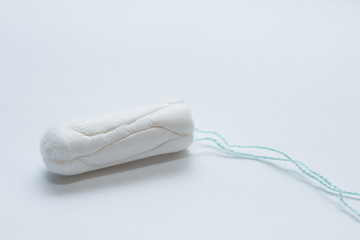 Menstrual tampon on a gray background. Side view