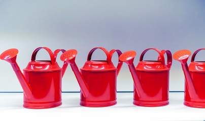 Metallic red watering cans for watering flowers and plants.