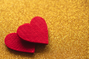 Red felt hearts on golden shiny background. Valentine's Day