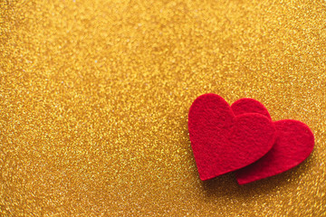 Red felt hearts on golden shiny background. Valentine's Day