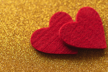 Red felt hearts on golden shiny background. Valentine's Day