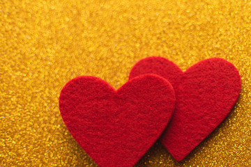 Red felt hearts on golden shiny background. Valentine's Day