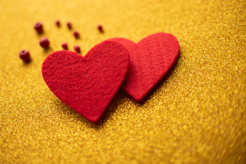 Red felt hearts on golden shiny background. Valentine's Day