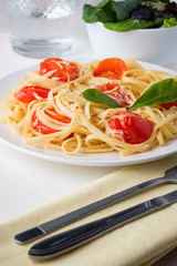Pasta spaghetti with tomato sauce and cheese parmesan served on dark plate on table background