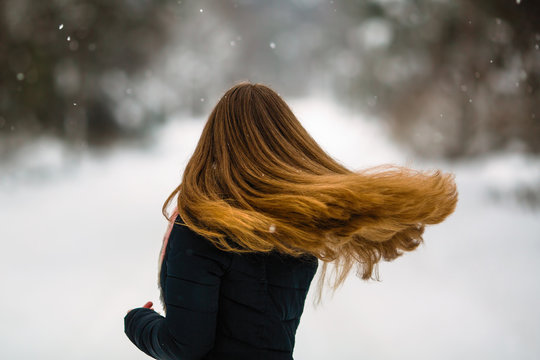 Girl's long hair. Fluttering beautiful сurls of young woman in winter outdoors.
