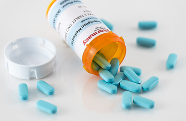 Prescription Pill Bottle with Spilled Blue Pills