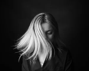 Foto op Plexiglas Dramatisch zwart-wit portret van een mooie vrouw op een donkere achtergrond © Restyler