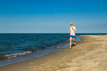 Man running, jumping on beach