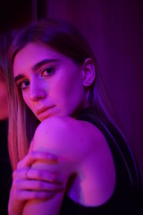 Fototapeta premium Sexy young beauty woman posing over night city dramatic red and blue neon background