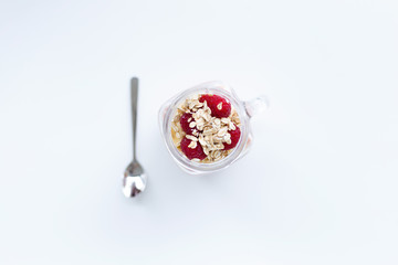 Strawberry and banana smoothie with seeds next to spoon on white background. Top view