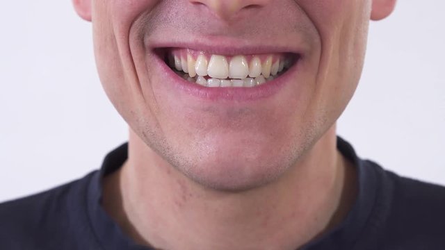 Close up shooting mouth of the mad man is smiling in wide unhealthy smile. Shooting on a white background.