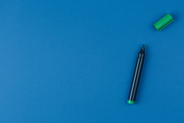 Naklejka premium green marker on the blue table top view
