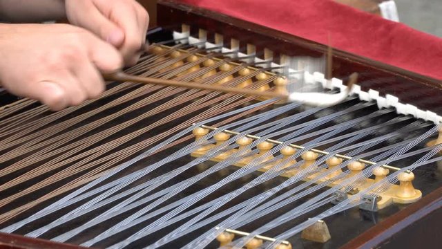 Hammered Dulcimer with player hands with hammers.